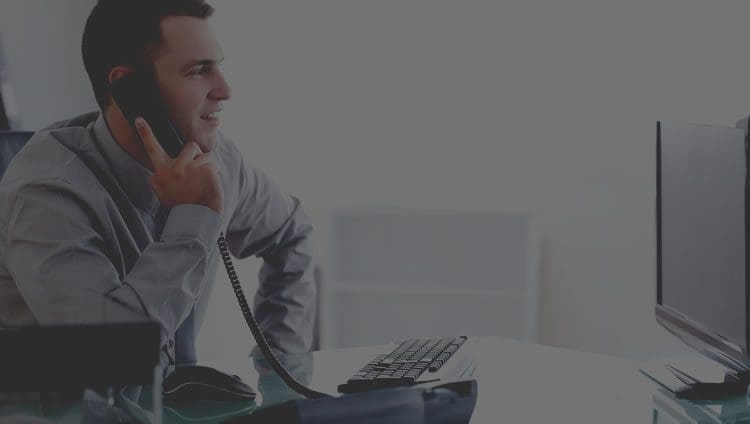 man sitting at desk on the phone
